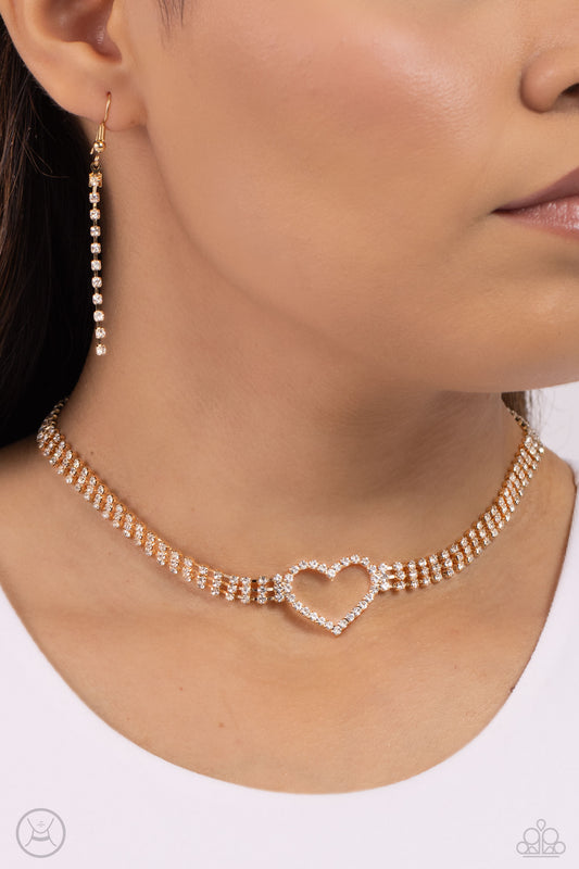 Rows of Romance Gold Heart Choker Necklace - Paparazzi Accessories  Featuring sleek square fittings, a dramatic white rhinestone heart-shaped frame glitters at the center of blinding rows of glassy white rhinestones also set in gold square fittings, resulting in a flirtatious sparkle around the neck. Features an adjustable clasp closure.  Sold as one individual choker necklace. Includes one pair of matching earrings.  P2CH-GDXX-124XX