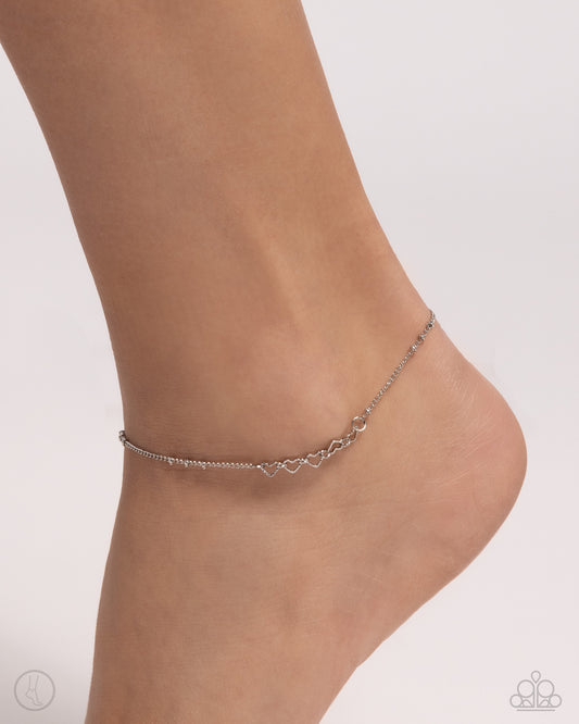 Satellite Shimmer Silver Heart Anklet - Paparazzi Accessories  Featured in the center of a silver satellite chain, silver heart silhouettes alternate in direction along the ankle for a subtly sweet statement. Features an adjustable clasp closure.  Sold as one individual anklet.  P9AN-SVXX-050XX