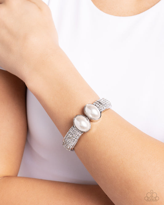 Balanced Brevity White Hinge Bracelet - Paparazzi Accessories  Featuring oversized white pearls, two shiny silver bars embellished with row after row of white rhinestones attach to a spring-like fitting as they curl around the wrist for a refined finish. Features a hinged closure.  Sold as one individual bracelet.  P9RE-WTXX-600XX