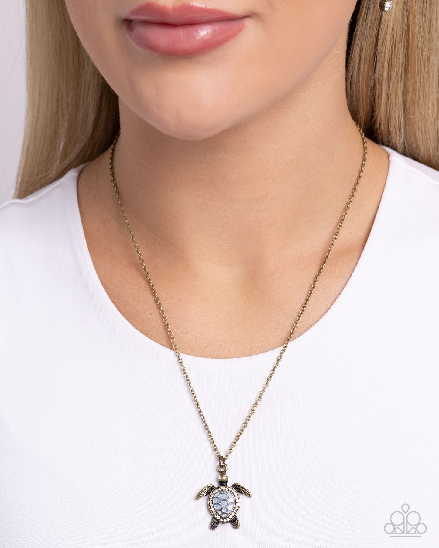 Turtle Tourist Brass Necklace - Paparazzi Accessories  Swimming along a dainty brass chain, an oversized brass turtle pendant with a Soft Chambray pearl-painted and white rhinestone embellished shell and eyes shimmers below the neckline for a classic, coastal look. Features an adjustable clasp closure.  Sold as one individual necklace. Includes one pair of matching earrings.  P2DA-BRXX-154XX