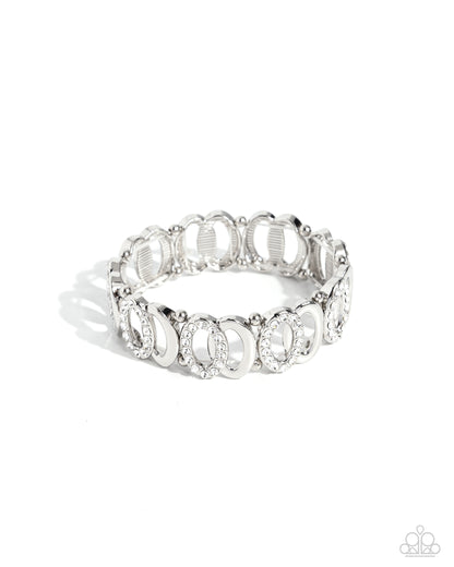 Refined Rarity White Rhinestone Stretch Bracelet - Paparazzi Accessories  A collection of two interlocking silver ovals, one encrusted in white rhinestones, separated by a duo of silver beads wraps along the wrist on elastic stretchy bands for a timeless, twisted look.  Sold as one individual bracelet.  P9RE-WTXX-596XX