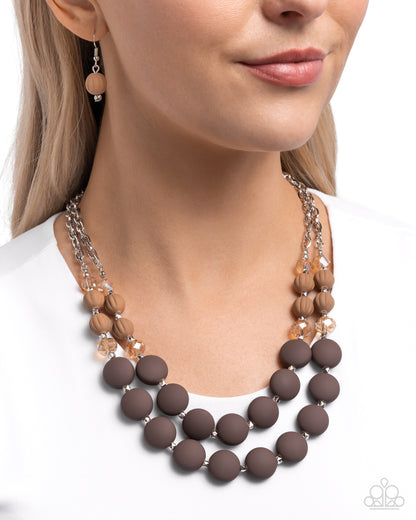 Whimsically Wealthy Brown Necklace - Paparazzi Accessories  Light-colored topaz faceted beads, silver beads, warm brown beads, and brown matte beads are infused along classic silver chains that layer below the neckline for a colorfully charismatic look. Features an adjustable clasp closure.  Sold as one individual necklace. Includes one pair of matching earrings.  P2WH-BNXX-247XX