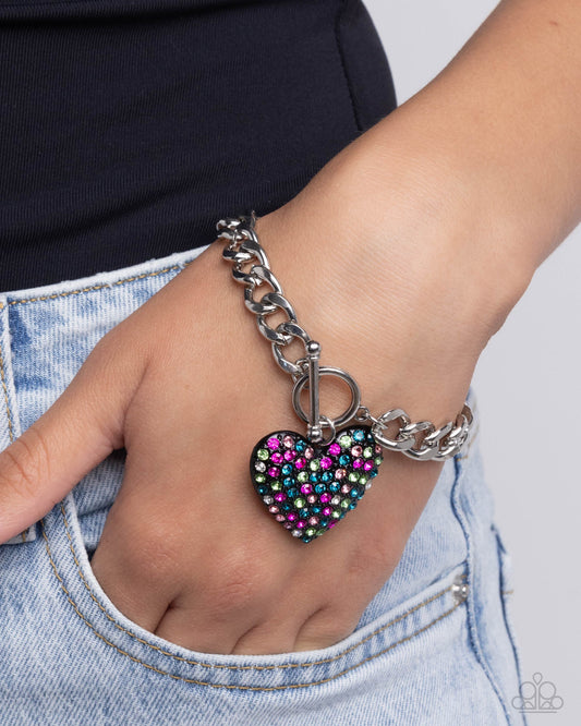 Enamored Elegance Black Heart Toggle Bracelet - Paparazzi Accessories  Featuring a collection of multicolored rhinestones, a black heart-shaped pendant sparkles from a toggle closure at the center of a silver curb chain for a flirtatious fashion around the wrist. Features a toggle closure.  Sold as one individual bracelet.  P9WH-BKXX-200XX