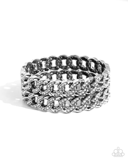 Braided Bandit White Stretch Bracelet - Paparazzi Accessories  Embellished with glistening white rhinestones, elongated silver curb chains stack atop one another to create a bold, stackable braided look along the wrist.  Sold as one individual bracelet.  P9ED-WTXX-060XX