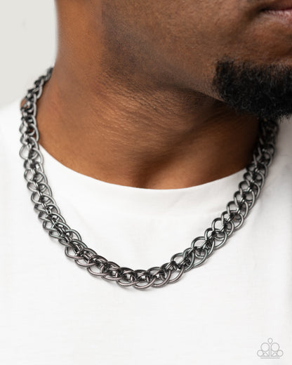 Coiled Conviction Black Unisex Necklace - Paparazzi Accessories  A collection of coiled gunmetal rings interlock between duos of sleek, high-sheen gunmetal rings along the neckline for a confidently chic look. Features an adjustable clasp closure.  Sold as one individual necklace.  P2MN-URBK-083XX