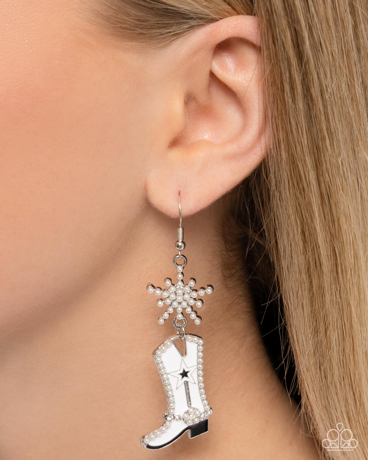 Compelling Cowboy White Boot Earring - Paparazzi Accessories  Embellished in dainty white pearls an explosive silver star gives way to a white-painted cowboy boot. Lined with black-painted details, white rhinestones, and similar dainty white pearls, the cowboy boot kicks below the ear for a Western whimsical look. Earring attaches to a standard fishhook fitting.  Sold as one pair of earrings.  P5SE-WTXX-232XX