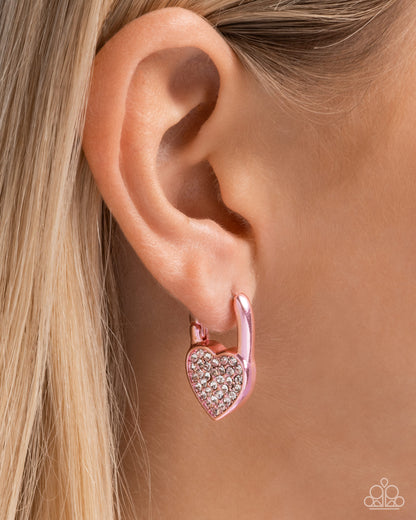 Padlocked Promise Pink Hinge Hoop Earring - Paparazzi Accessories  Modeled after a padlock, a pink-painted heart frame is embellished with white rhinestones for a shimmery sealed look along the ear. Earring attaches to a standard hinge closure fitting. Hoop measures approximately 1/2" in diameter.  Sold as one pair of hinge hoop earrings.  P5HO-PKXX-102XX