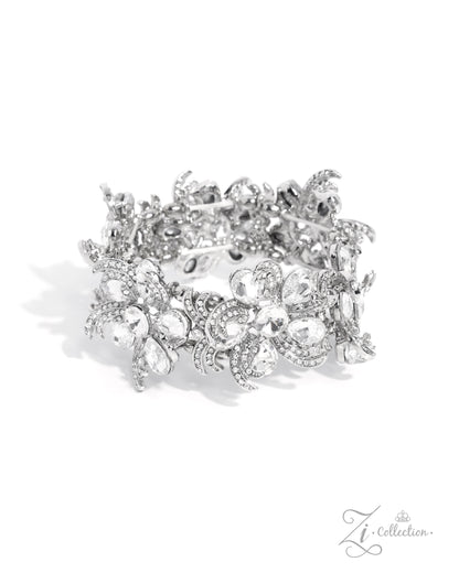 Indulgent Ideal White Rhinestone Stretch Zi Bracelet - Paparazzi Accessories  Item #Z2425  Curls of white rhinestone-embellished silver frames in varying sizes and white teardrop gems bloom around shimmery luminescent round centerpieces into a collection of unique flowers adorned in dizzying, intricate detail. The flourish of florals is threaded whimsically around the wrist on elastic stretchy bands, resulting in an unforgettable statement piece that sparkles with sentiment.  Sold as one individual bracelet