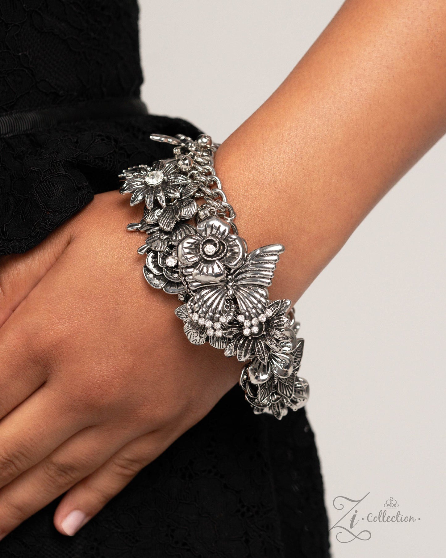 Intentional Impression Silver Butterfly Clasp Bracelet - Paparazzi Accessories  Item #Z2423  A whimsical collection of shimmery luminescent and intricate detailed silver charms — including rhinestone-embellished flowers and airy butterflies — dance from a chunky silver chain around the wrist, creating a boisterous, blissful fringe. Features an adjustable clasp closure.  Sold as one individual bracelet.