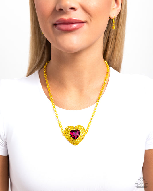 Locket Leisure Yellow Heart Necklace - Paparazzi Accessories  Featuring a bright yellow hue, an oversized heart pendant dangles from a classic chain also dipped in the bright color. Glittering around a fuchsia heart gem center, yellow rhinestones fan out atop the frame for additional shimmer and color. Features an adjustable clasp closure.  Sold as one individual necklace. Includes one pair of matching earrings.  P2ST-YWXX-098XX