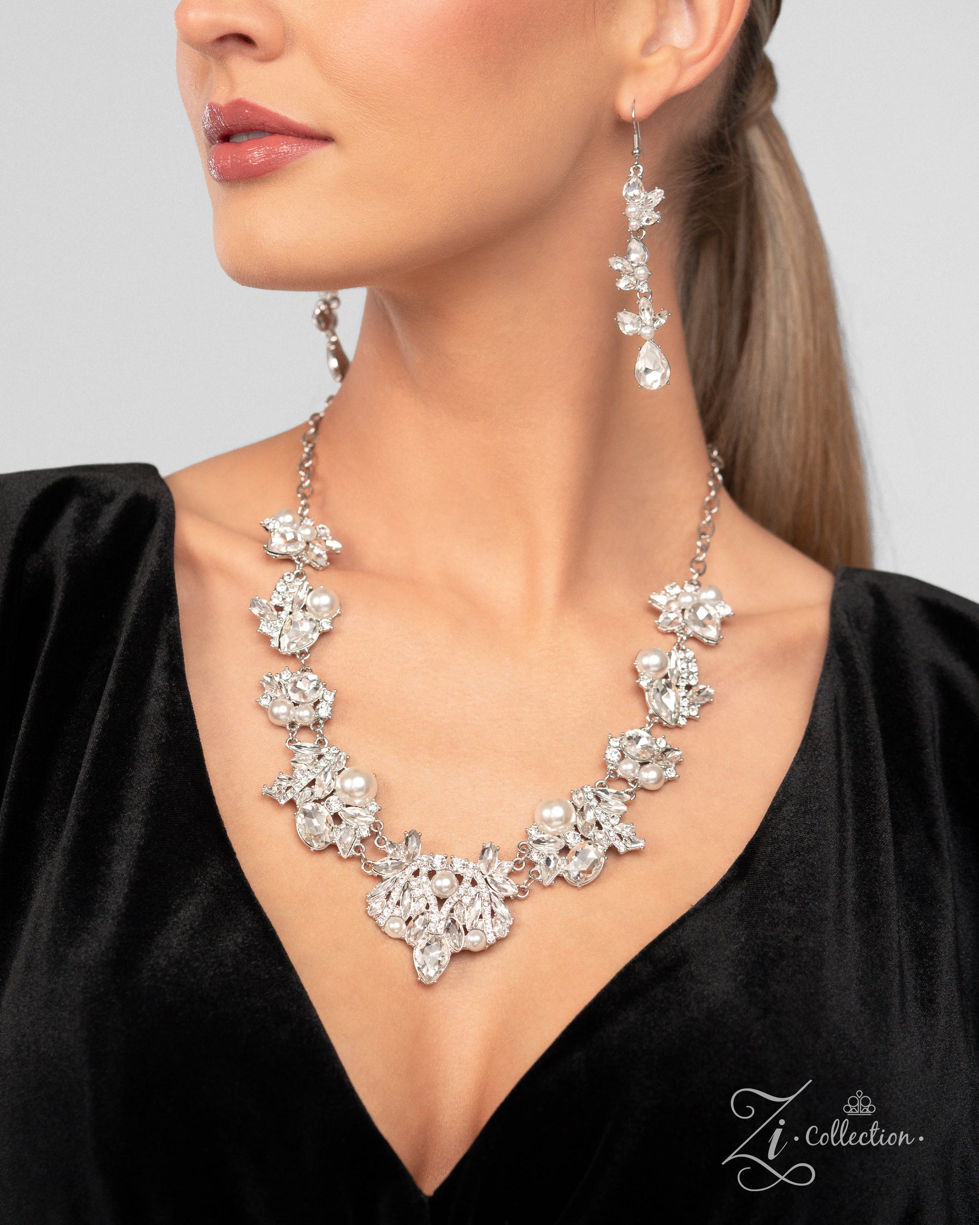 The Aleshia White Pearl 2024 Zi Necklace - Paparazzi Accessories  Item #Z2410   Clusters of marquise-cut and teardrop gems, round white rhinestones, white pearls, and pieces of rhinestone-encrusted silver bars link together along the collar, creating an explosion of extravagant sparkle. The dramatic angles of the silver bars exaggerate the dramatic crystal-like radiance of each pronged gem, adding further dimension to the design. The size and intensity of the radically refined clusters slowly increase as th