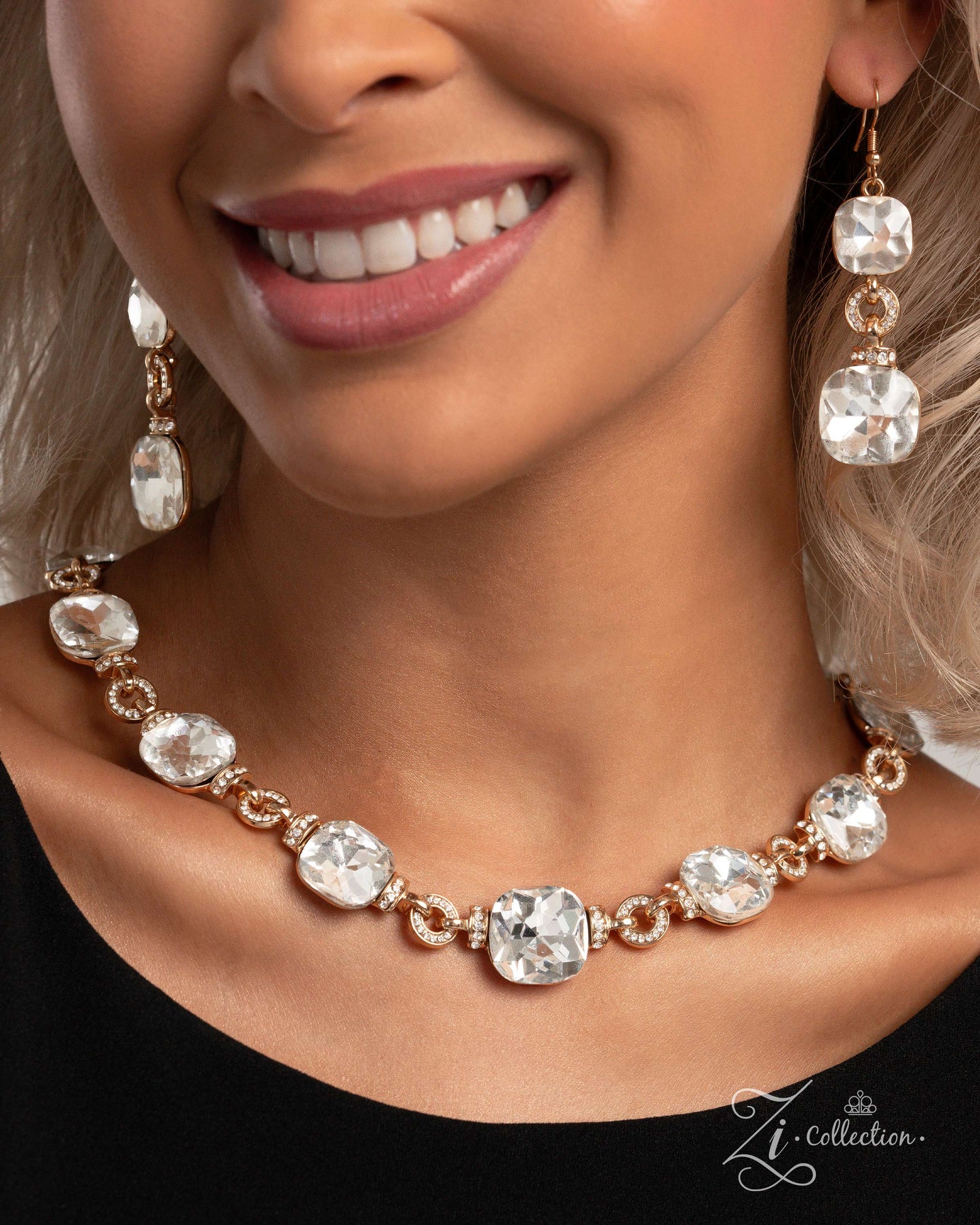 The Crystal Gold 2024 Zi Necklace - Paparazzi Accessories  Item #Z2401  A solitaire row of dramatically asscher-cut white gems sparkles blindingly along the collar, bordered by white rhinestone-encrusted round gold fittings. White rhinestone-encrusted gold rings alternate alongside the gems giving this showstopper some exaggerated depth and dazzle. Features an adjustable clasp closure.  Sold as one individual necklace. Includes one pair of matching earrings.&nbsp;  Named after the 2024 Seize the Spotlight w