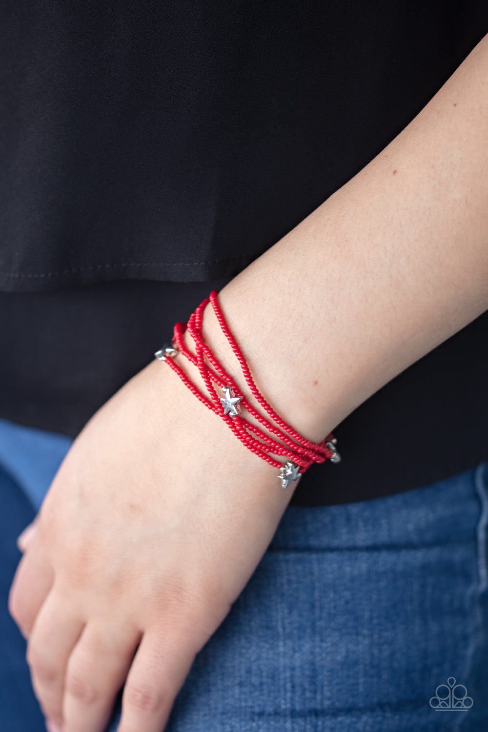 Pretty Patriotic Red Bracelet - Paparazzi Accessories  Dotted with shiny silver star charms, a colorful assortment of dainty red seed beads are threaded along stretchy bands, creating stellar layers.  ﻿All Paparazzi Accessories are lead free and nickel free!  Sold as one set of five bracelets.