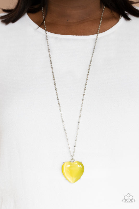 Warmhearted Glow Yellow Necklace - Paparazzi Accessories  An oversized Illuminating cat's eye stone frame swings from the bottom of a lengthened silver chain, creating a flirtatious pendant. Features an adjustable clasp closure.  All Paparazzi Accessories are lead free and nickel free!  Sold as one individual necklace. Includes one pair of matching earrings.