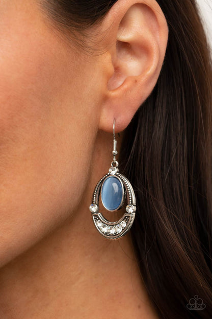 Serene Shimmer Blue Earring - Paparazzi Accessories.  A glowing blue cat's eye stone attaches to the top of a studded silver frame. The bottom of the oval is encrusted in glassy white rhinestones, creating a whimsical display. Earring attaches to a standard fishhook fitting.  ﻿﻿﻿All Paparazzi Accessories are lead free and nickel free!  Sold as one pair of earrings.