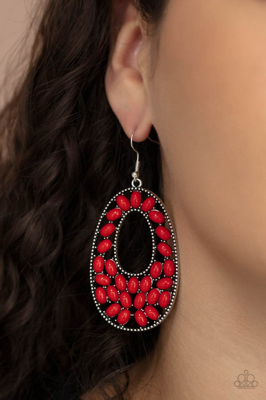 Beaded Shores Red Earring - Paparazzi Accessories. A collection of oval red beads collect inside a studded silver oval frame, creating a bright pop of color. Earring attaches to a standard fishhook fitting.  All Paparazzi Accessories are lead free and nickel free!  Sold as one pair of earrings.