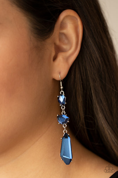 Sophisticated Smolder Blue Earring - Paparazzi Accessories  Featuring raw cuts, an asymmetrical collection of faceted blue gems trickles from the ear, creating a smoldering chandelier. Earring attaches to a standard fishhook fitting.  All Paparazzi Accessories are lead free and nickel free!  Sold as one pair of earrings.