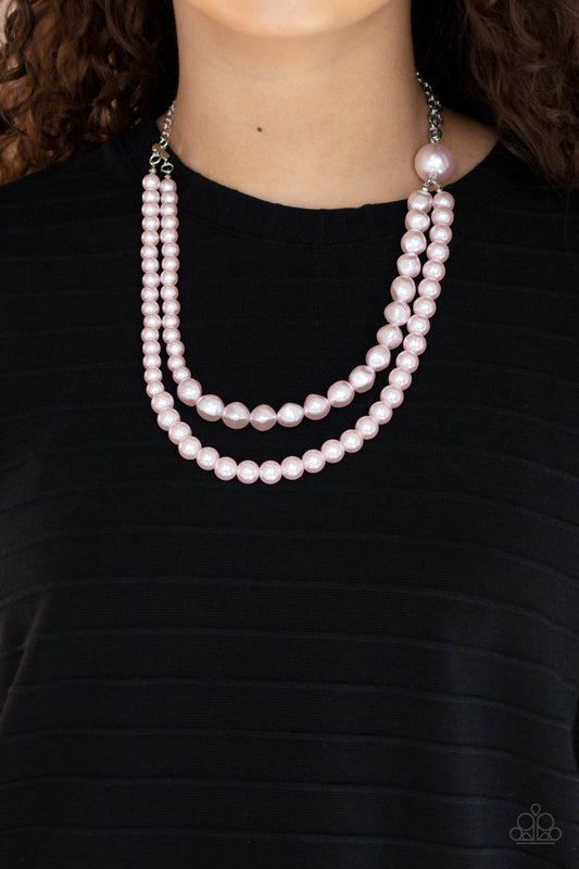 Remarkable Radiance Pink Pearl Necklace - Paparazzi Accessories  A dramatically oversized pink pearl gives way to two mismatched strands of classic pink pearls that graduate in size and imperfect finishes, adding a timeless twist to the classic pearl palette. Features an adjustable clasp closure.  All Paparazzi Accessories are lead free and nickel free!  Sold as one individual necklace. Includes one pair of matching earrings.