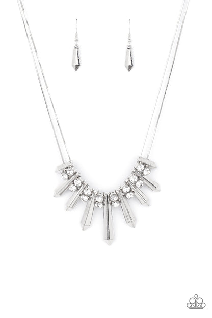 Dangerous Dazzle White Necklace - Paparazzi Accessories  Pairs of glittery white rhinestones alternate between flared silver rods that are threaded along two rows of flat silver chains, creating a dangerous fringe below the collar. Features an adjustable clasp closure.  All Paparazzi Accessories are lead free and nickel free!   Sold as one individual necklace. Includes one pair of matching earrings.