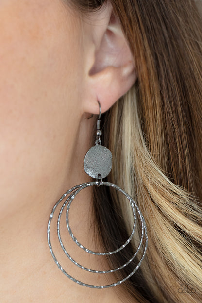 Universal Rehearsal Black Earring - Paparazzi Accessories  A shimmery wavy gunmetal disc links atop a collection of three delicately hammered gunmetal rings in concentric sizes for an out-of-this-world finish. Earring attaches to a standard fishhook fitting.  ﻿All Paparazzi Accessories are lead free and nickel free!  Sold as one pair of earrings.