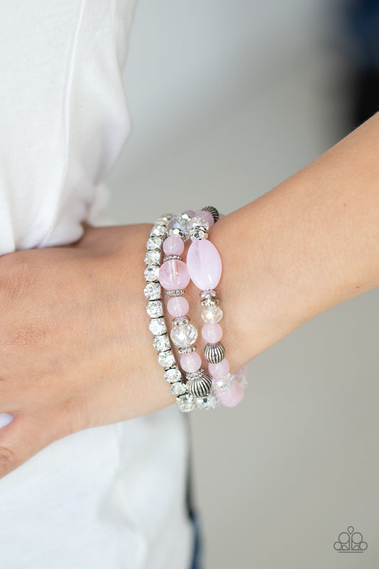 Ethereal Etiquette Pink Bracelet - Paparazzi Accessories  Infused with a stretchy strand of glassy white rhinestones, a mismatched collection of cloudy pink, white crystal-like, and ornate silver accents are threaded along stretchy bands around the wrist, creating ethereal layers.  All Paparazzi Accessories are lead free and nickel free!  Sold as one set of three bracelets.