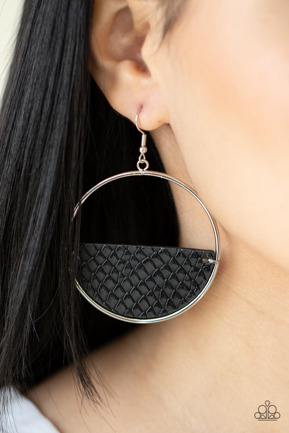 Animal Aesthetic Black Leather Earring - Paparazzi Accessories  Featuring a python print, a half moon piece of rustic black leather is fitted in place along the bottom of an oversized silver hoop for a wonderfully wild look. Earring attaches to a standard fishhook fitting.   Sold as one pair of earrings.