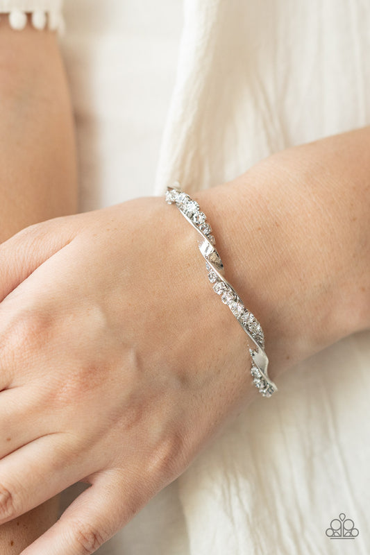 Twisted Twinkle White Cuff Bracelet - Paparazzi Accessories  A glittery strand of glassy white rhinestones twists with a shiny silver bar around the wrist, creating a dainty cuff.  Sold as one individual bracelet.