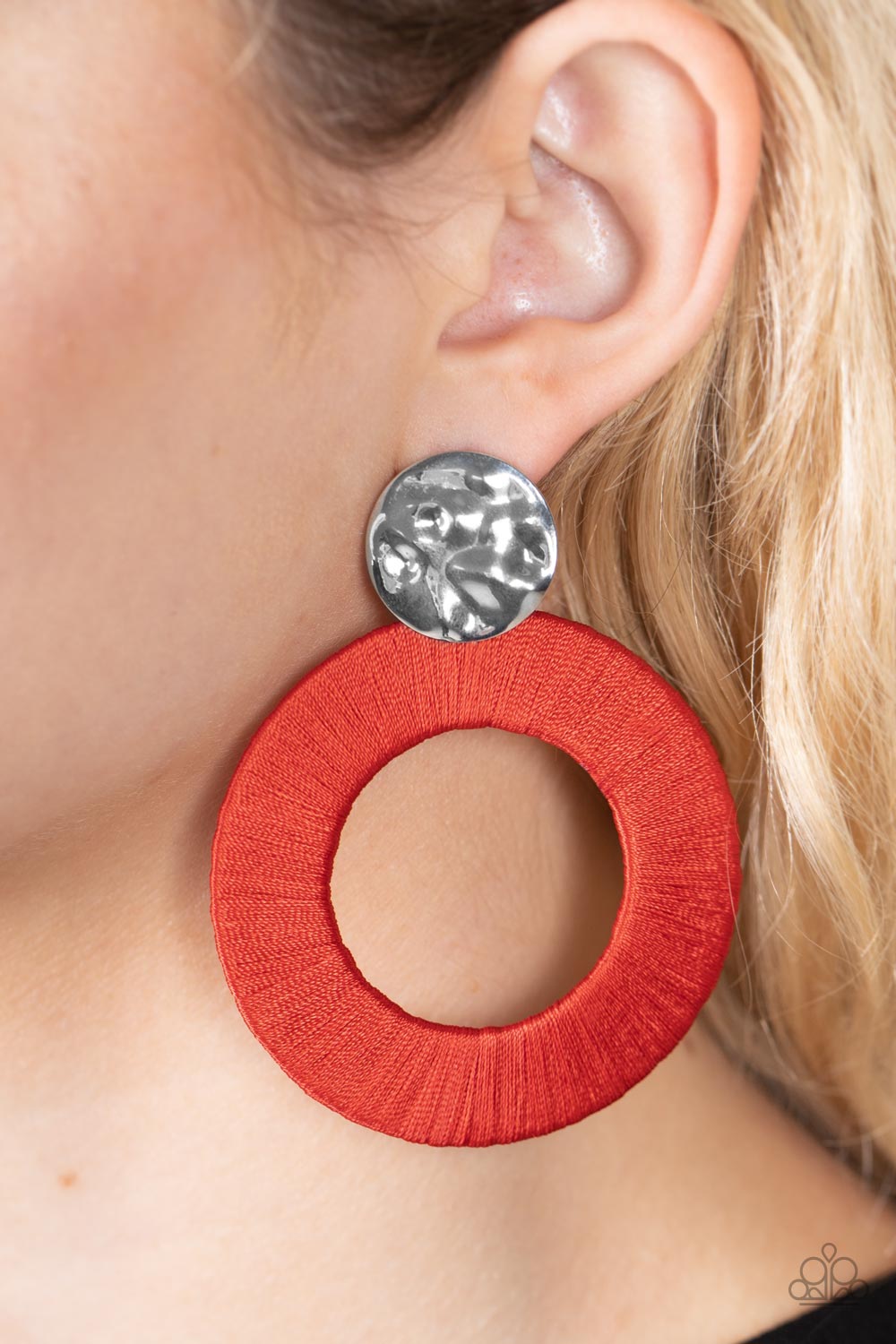 Strategically Sassy Red Earring - Paparazzi Accessories  A hammered silver disc gives way to an oversized metal hoop wrapped in fiery red thread, resulting in a modern lure. Earring attaches to a standard post fitting.  Sold as one pair of post earrings.