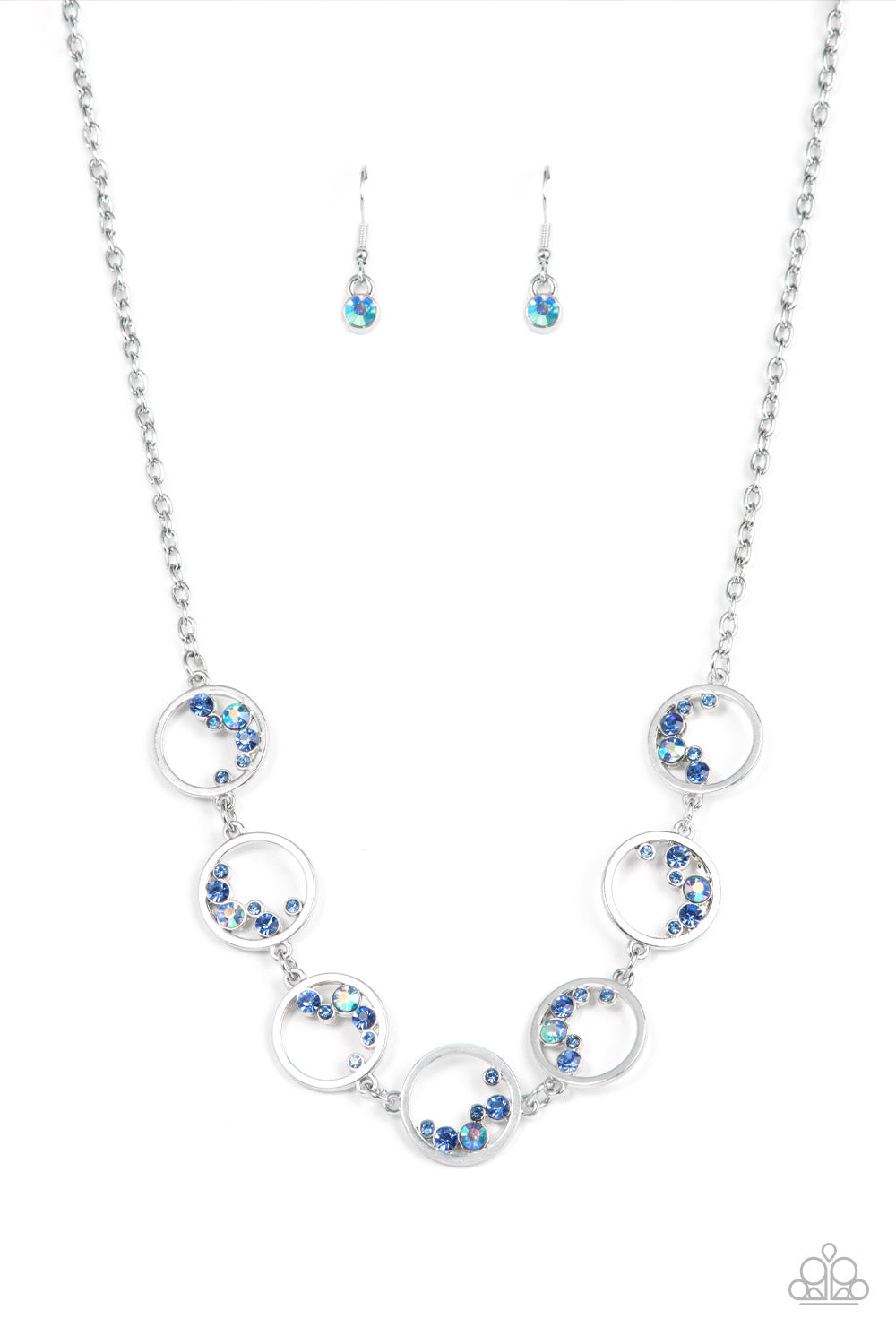 Blissfully Bubbly Blue Necklace - Paparazzi Accessories  A dainty series of shiny silver rings are sporadically dotted in bubbly rows of glassy and iridescent blue rhinestones as they delicately link below the collar, resulting in an effervescent display. Features an adjustable clasp closure.  Sold as one individual necklace. Includes one pair of matching earrings.