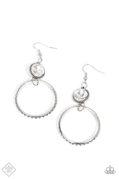 Standalone Sparkle White Earring - Paparazzi Accessories  The outer edge of a silver ring is stamped with a flattened dot motif as it swings below a dramatic white rhinestone that sparkles inside a daintily dotted antiqued silver frame, creating an upscale, edgy modern lure. Earring attaches to a standard fishhook fitting.  Sold as one pair of earrings.