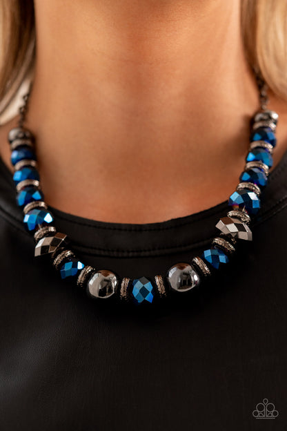 Interstellar Influencer Blue Necklace - Paparazzi Accessories  A dramatic assortment of oversized gunmetal beads, textured gunmetal rings, and faceted metallic blue gems delicately glides along an invisible wire below the collar, resulting in a stellar sparkle. Features an adjustable clasp closure. Includes one pair of matching earrings.