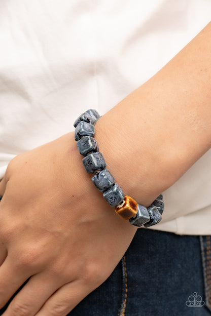 Glaze Craze Blue Urban Bracelet - Paparazzi Accessories  Featuring distressed blue and brown glazed finishes, a rustic collection of ceramic cube beads are threaded along stretchy bands around the wrist for a colorful flair.  Sold as one individual bracelet.