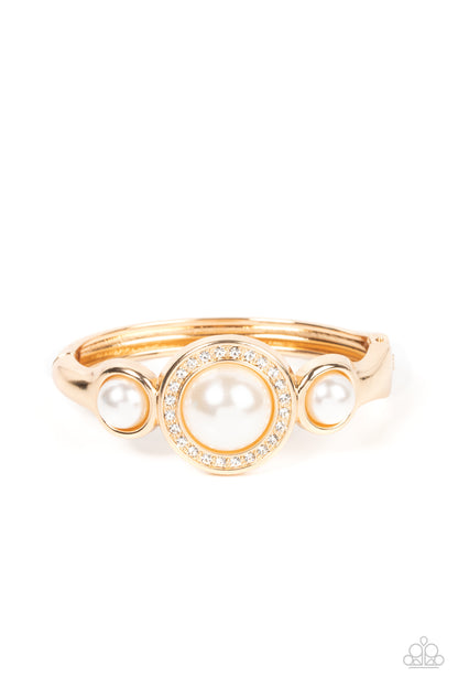 Debutante Daydream - Gold Item #P9RE-GDXX-321XX Encircled in a glitzy ring of glassy white rhinestones, an oversized white pearl is flanked by a pair of bubbly white pearl fittings atop a classic gold bangle-like bracelet for a timeless twist. Features a hinged closure.  Sold as one individual bracelet.