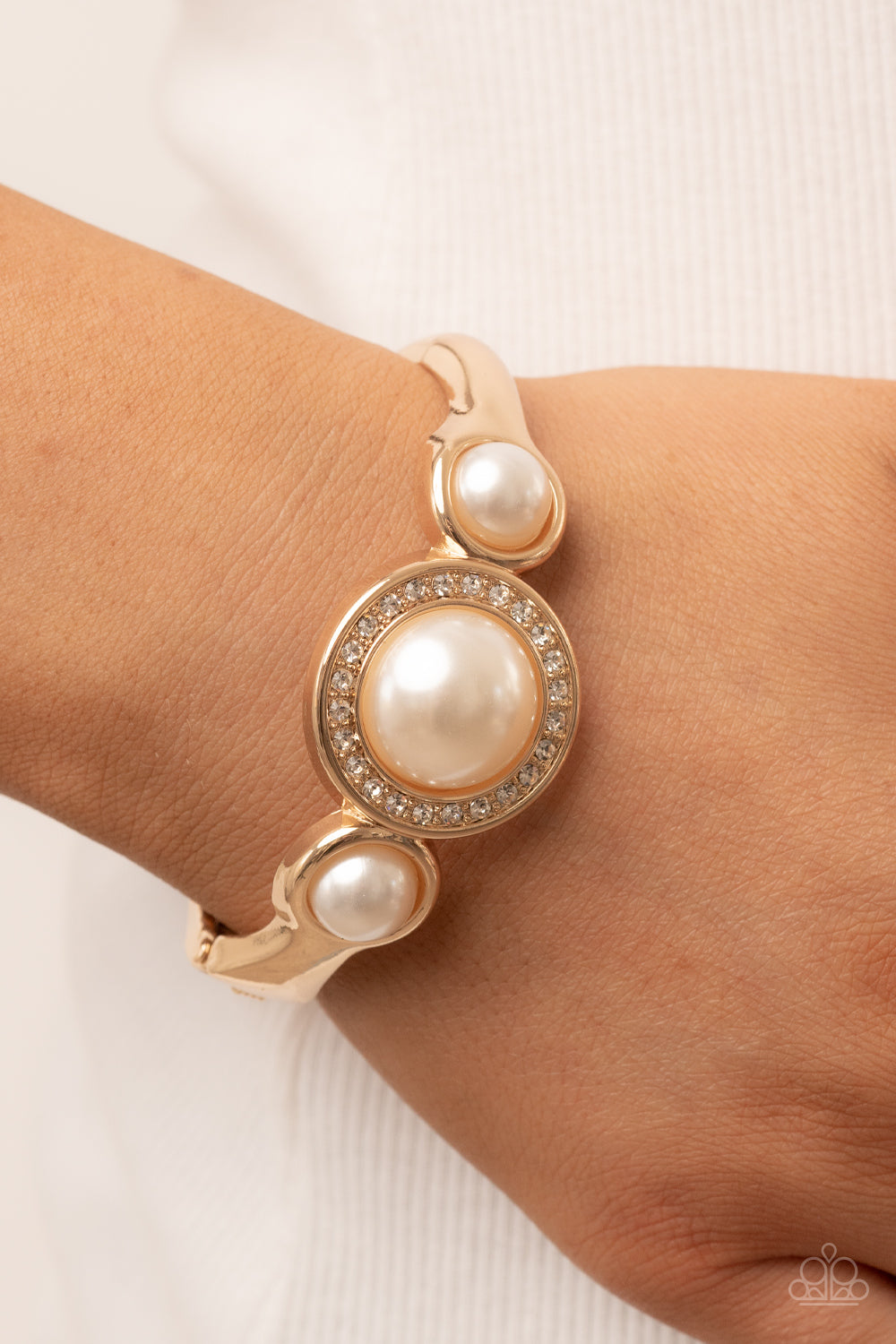 Debutante Daydream - Gold Item #P9RE-GDXX-321XX Encircled in a glitzy ring of glassy white rhinestones, an oversized white pearl is flanked by a pair of bubbly white pearl fittings atop a classic gold bangle-like bracelet for a timeless twist. Features a hinged closure.  Sold as one individual bracelet.