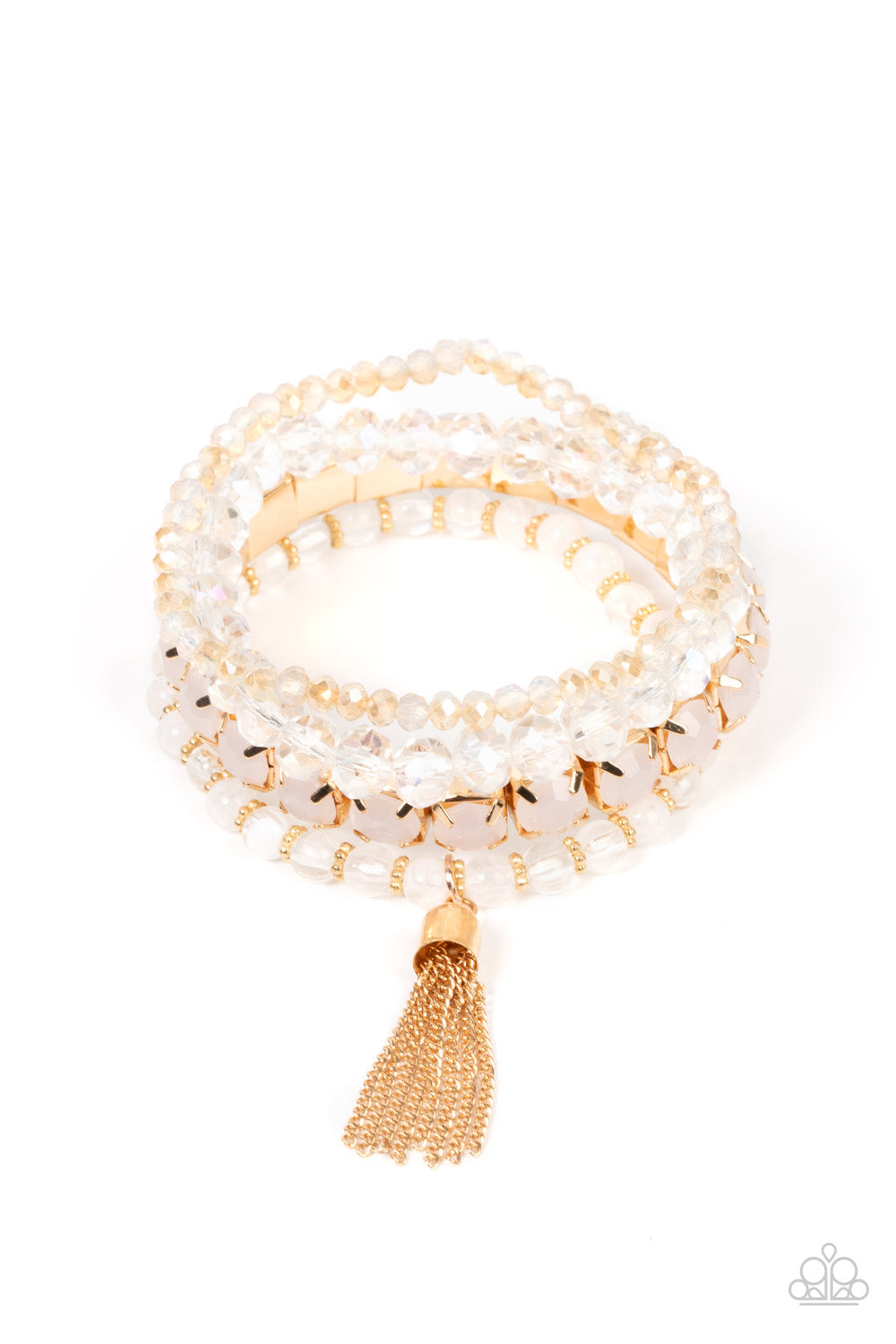 Day Trip Trinket Gold Bracelet - Paparazzi Accessories  Pinched in gold fittings, a stretchy band of dewy rhinestones joins mismatched strands of golden, glassy, and iridescent crystal-like and stretchy bracelets around the wrist. A single gold chain tassel dances from the crystalline compilation for a final flirty finesse.  Sold as one set of four bracelets.