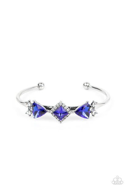 Strategic Sparkle Blue Cuff Bracelet - Paparazzi Accessories   Bordered in glassy white rhinestones, a square cut blue rhinestone is flanked by a pair of triangular blue gems across the front of a dainty silver cuff. Clusters of dainty white rhinestones adorn the sides of the centerpiece for a glitzy and glamorous finish.  Sold as one individual bracelet.