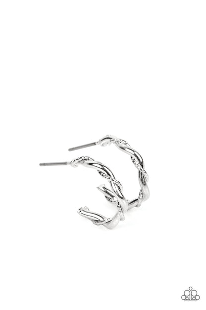 Irresistibly Intertwined Silver Hoop Earring - Paparazzi Accessories  A mismatched pair of shiny silver wires delicately twists into a classic hoop, creating a dainty peek of shimmer. Earring attaches to a standard post fitting. Hoop measures approximately 1/2" in diameter.  Sold as one pair of hoop earrings.