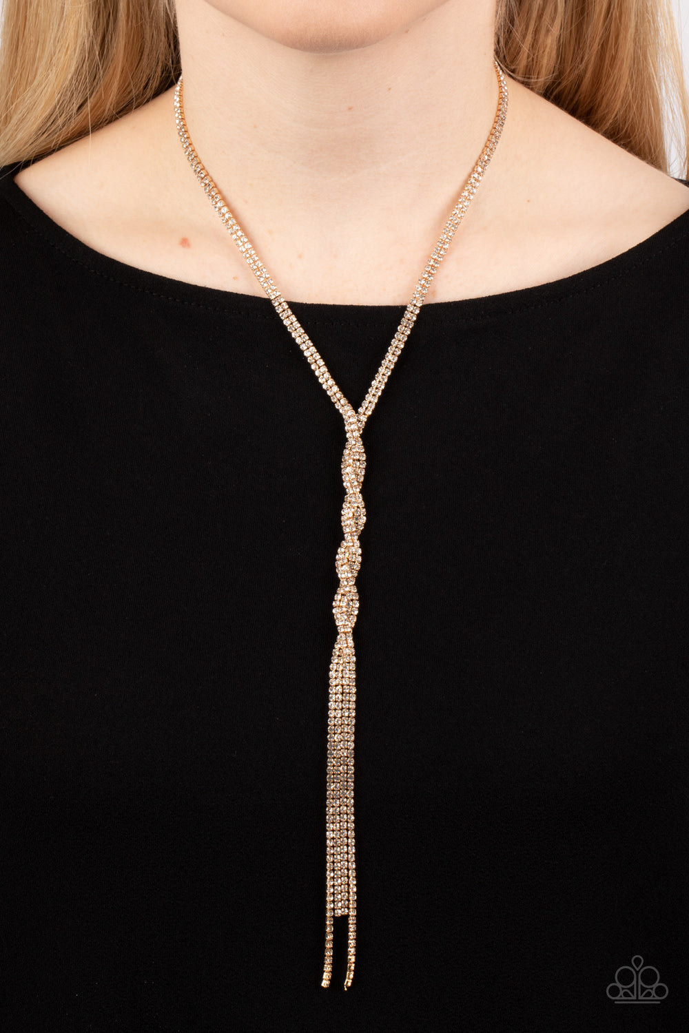 Impressively Icy Gold Necklace - Paparazzi Accessories  Golden ribbons of glassy white rhinestones loop around the neck and delicately twist into an icy tassel down the chest. Features an adjustable clasp closure.  Sold as one individual necklace. Includes one pair of matching earrings.