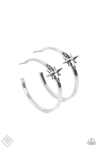 Lone Star Shimmer White Hoop Earring - Paparazzi Accessories  A three-dimensional silver star, dotted with a single dainty white rhinestone, is affixed to the front of a curved silver bar, forming an out-of-this-world hoop earring. Hoop measures approximately 1½ inches.  Sold as one pair of hoop earrings.