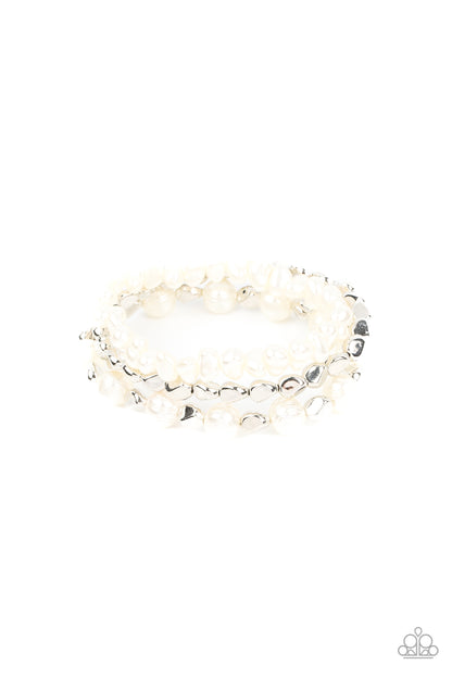 Shoreside Soiree White Bracelet - Paparazzi Accessories  Etched in natural inspired texture, oversized white pearls alternate with faceted silver beads along a stretchy band around the wrist. The imperfect pearl centerpiece layers with a pair of faceted silver and white pebble-like pearls, resulting in timeless layers.  Sold as one set of three bracelets.