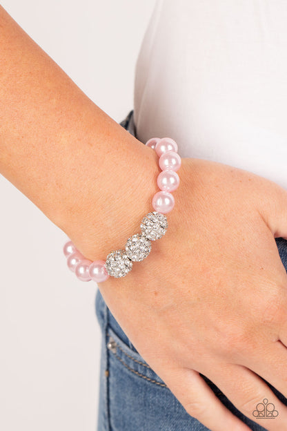 Breathtaking Ball Pink Pearl Bracelet - Paparazzi Accessories  A trio of silver beads encrusted in rhinestones is centered along a strand of classic baby pink pearls. The beads are threaded along a stretchy band, wrapping around the wrist in a refined finish.  Sold as one individual bracelet.  P9RE-PKXX-286XX