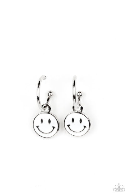 Subtle Smile White Hoop Earring - Paparazzi Accessories  A small, skinny, silver hoop curves around the ear, where a silver ball is affixed to create the look of a barbell. A white disc slides along the hoop, cheerfully showcasing a silver smiley face that adorns its colorful surface. Earring attaches to a standard post fitting. Hoop measures approximately 1/2" in diameter.  Sold as one pair of hoop earrings.