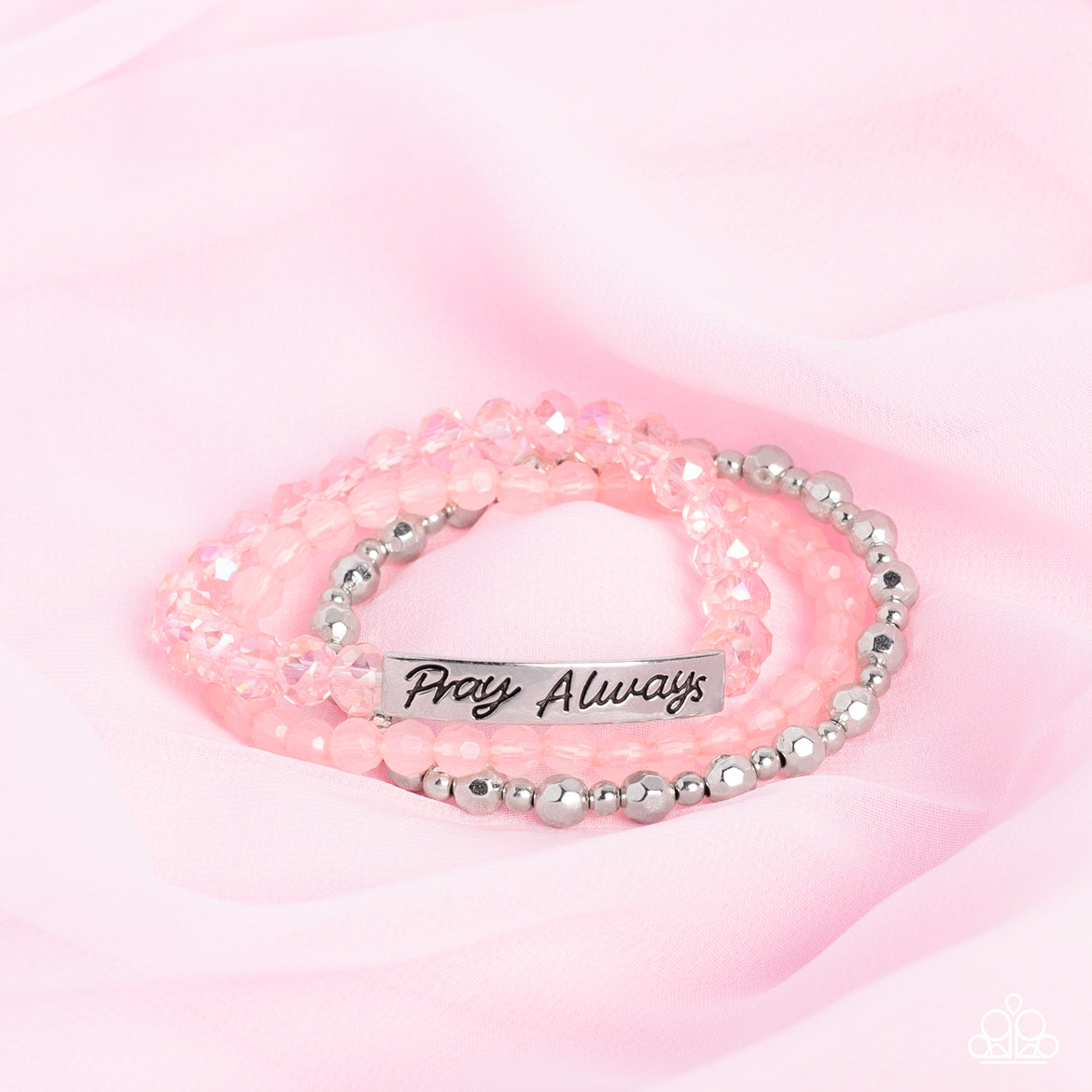 Pray Always Pink Bracelet - Paparazzi Accessories  Varying in shape and shimmer, faceted silver beads, milky pink beads, and glittery pink crystal-like beads are threaded along elastic stretchy bands, creating colorful layers across the wrist. Featured on the crystal-like band, a curved silver bar features the words "Pray Always" in a curly, stamped font for a soft finish.  Sold as one individual bracelet.