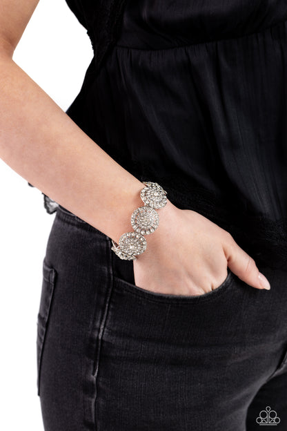 Executive Elegance White Stretch Bracelet - Paparazzi Accessories  Featuring a wheel motif, concaved silver discs embossed in an explosion of white rhinestones slide along a stretchy band around the wrist for a hint of dazzling refinement.  Sold as one individual bracelet.  P9RE-WTXX-576XX