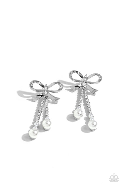 Bodacious Bow White Post Earring - Paparazzi Accessories  Adorned in sparkling white rhinestones, high-sheen bands of silver curl and loop into a stunning bow charm, creating a classy statement at the ear. White rhinestones encased in scalloped silver fittings, featuring white pearls that slowly increase in size dangle from the bow charm adding a refined tassel to the stunning display. Earring attaches to a standard post fitting.  Sold as one pair of post earrings.  P5PO-WTXX-383XX