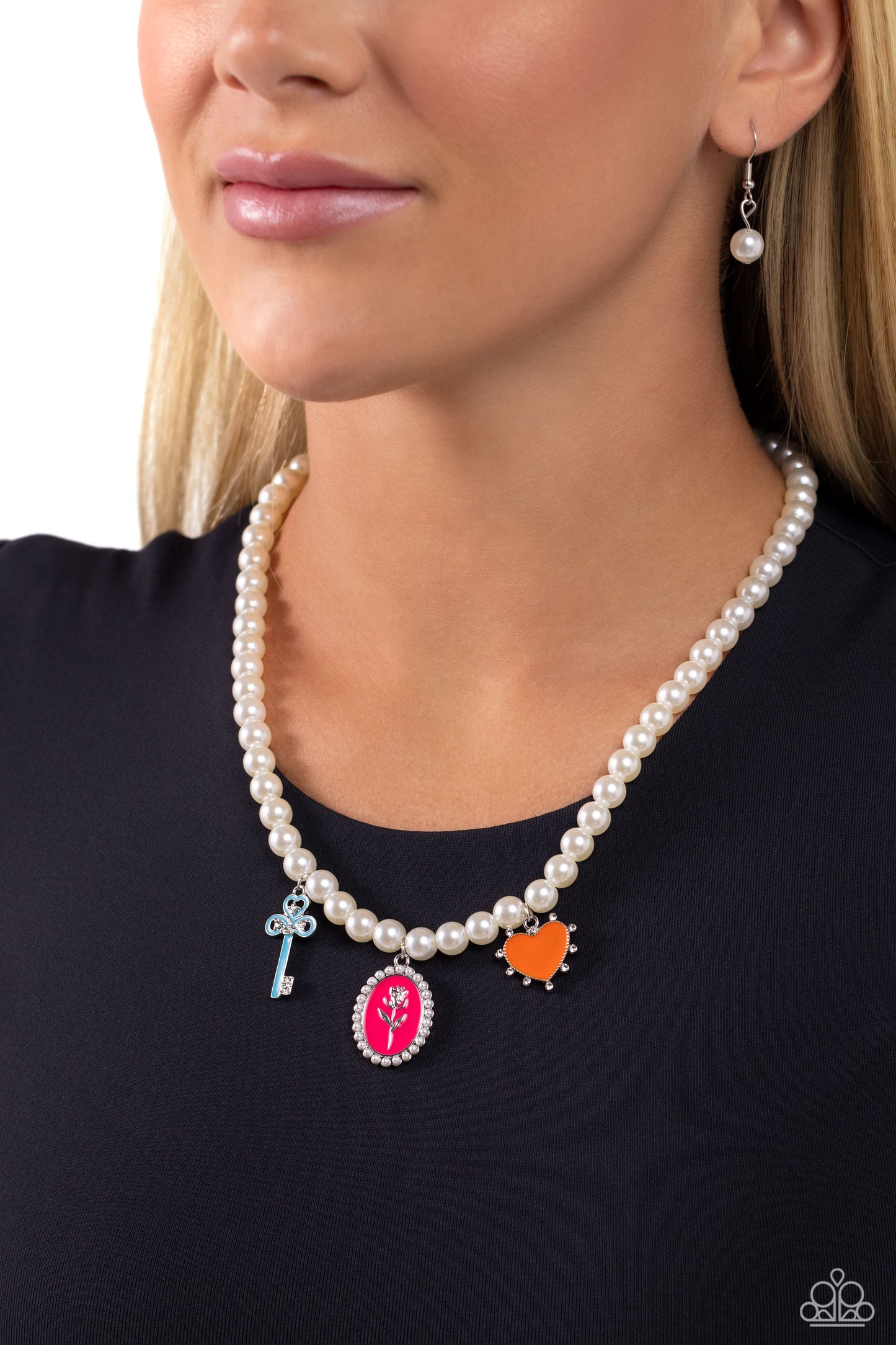 Charming Collision Multi Pearl Charm Necklace - Paparazzi Accessories  Infused along an invisible string, a collection of gleaming white pearls coalesces below the collar for a refined display. Featuring white rhinestones and dainty pearl accents, three Pink Peacock, orange, and blue painted charms, including a key, rose pendant, and studded heart, dangle below the pearly display for a girly pop of color. Features an adjustable clasp closure.